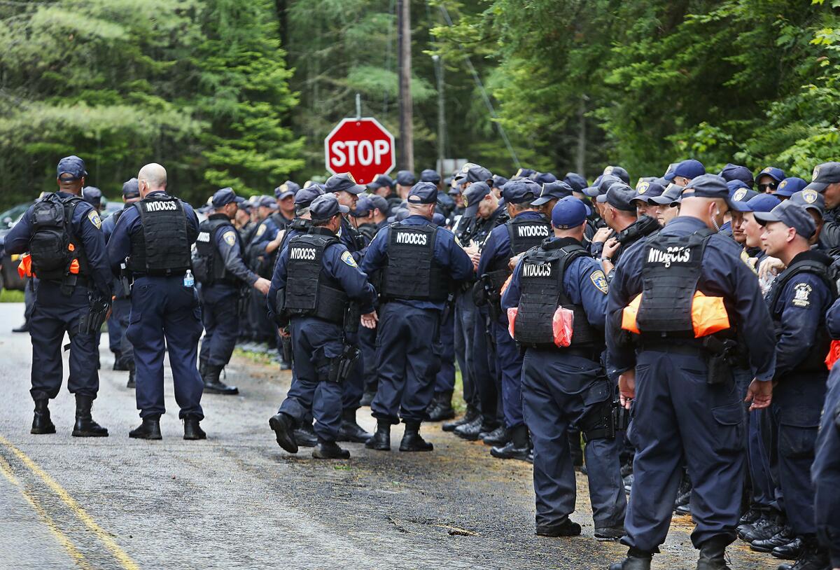 Un grupo de agentes del Departamento Correccional del estado de Nueva York se congregan como parte de la búsqueda de dos asesinos convictos que se escaparon de un penal de alta seguridad hace dos semanas. (Jason Hunter/The Watertown Daily Times via AP)