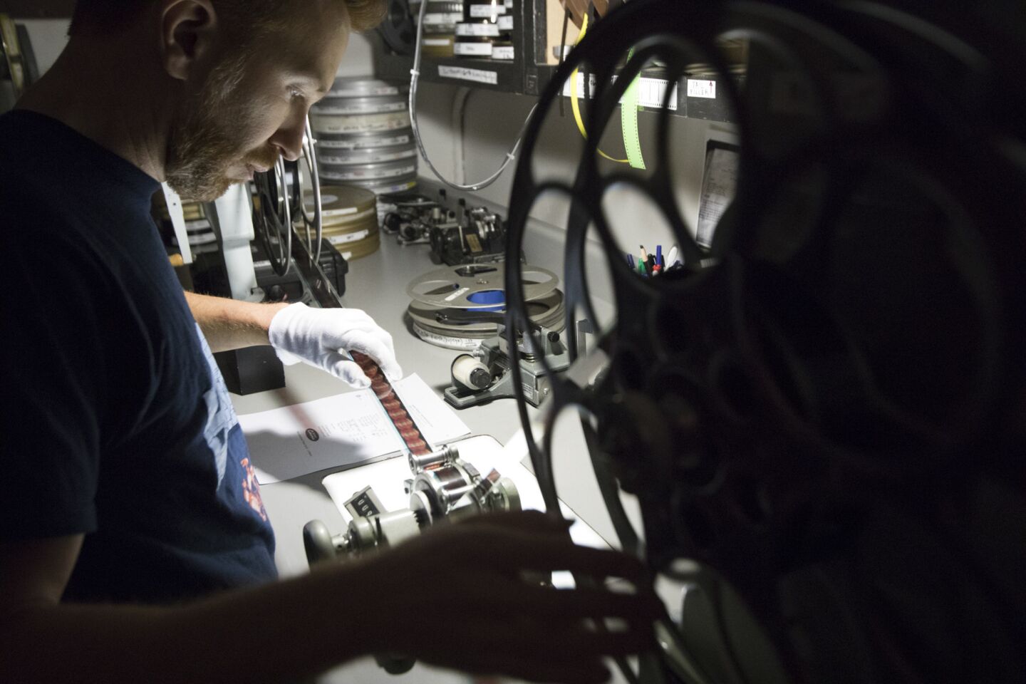 New Beverly Cinema archivist Aaron Martz inspects a film to make sure it's not damaged and is ready for its next screening.