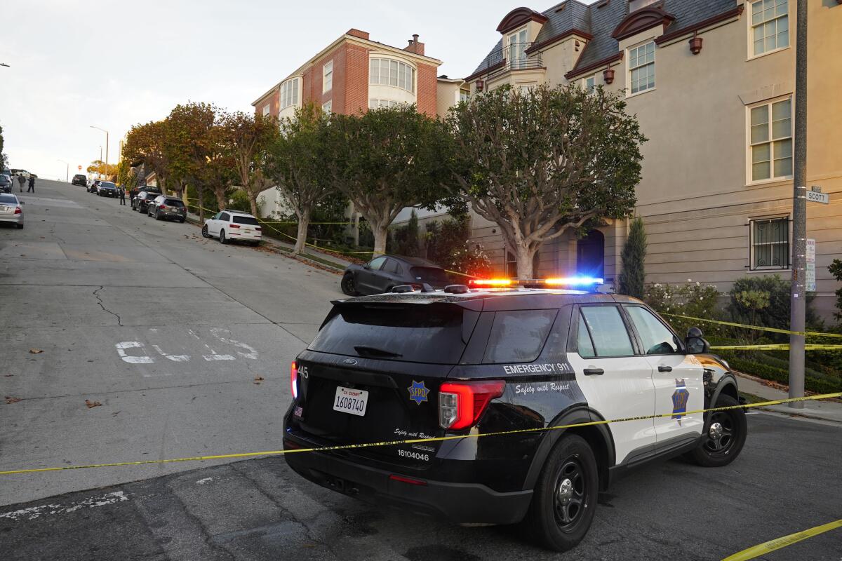A police car and yellow crime tape block the street below the home of Paul Pelosi in San Francisco.