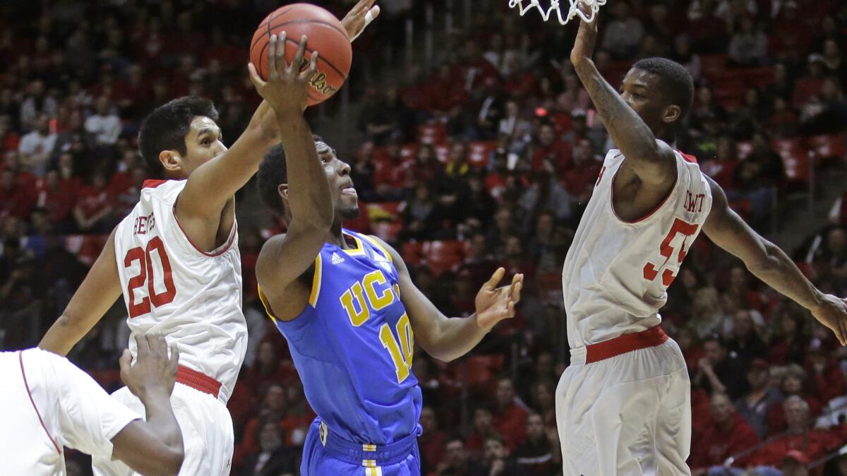 UCLA guard Isaac Hamilton, center, puts up a shot between Utah's (from left) Chris Reyes and Delon Wright during the first half of the Bruins' loss Sunday.