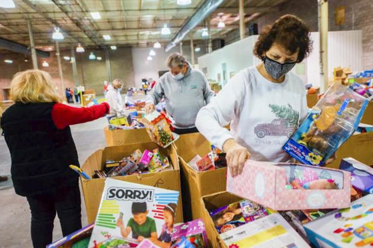 Volunteers sort bins full of items at a Toys for Tots event
