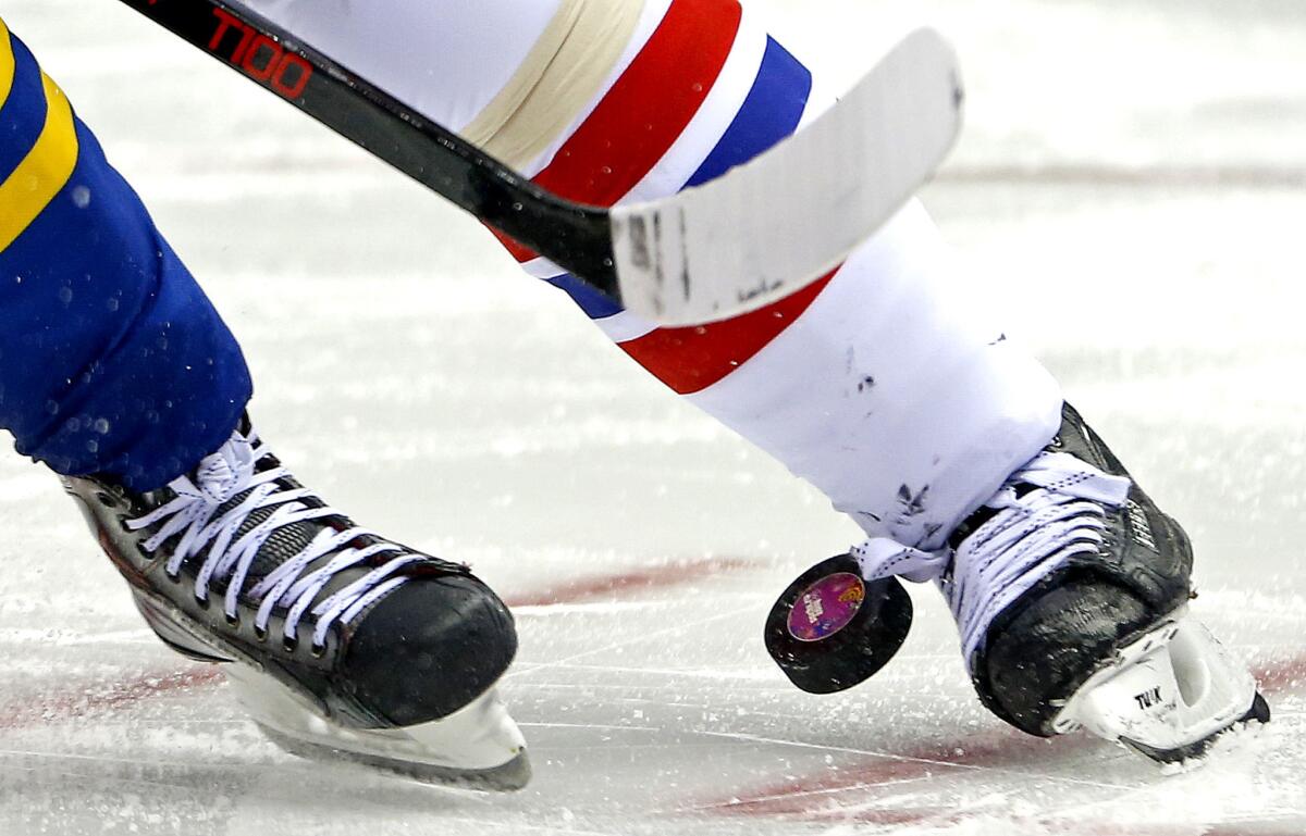 Hockey players face off on the ice.