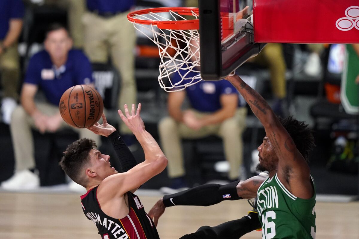 Miami Heat guard Tyler Herro takes a shot as Boston Celtics' Marcus Smart defends.