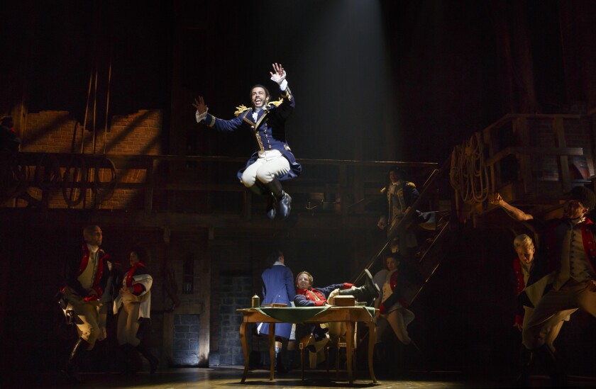 Daveed Diggs (as the Marquis de Lafayette) leaps from a table in the musical "Hamilton"