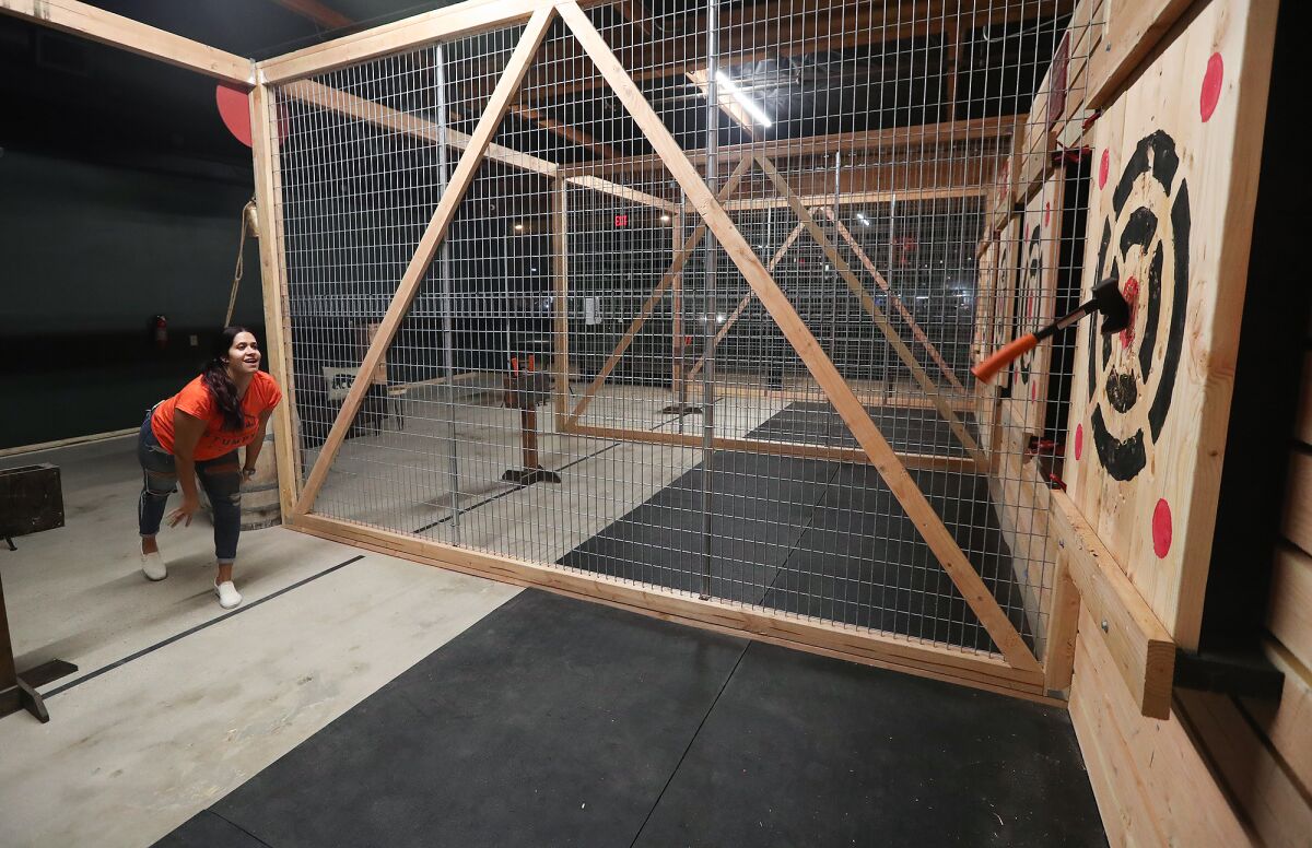 Kalie Peterson hits the bullseye as she throws hatchets at the opening of Stumpy's Hatchet House in Huntington Beach.