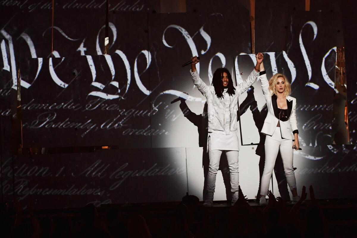 Skip Marley and Katy Perry, in a symbolic white pantsuit and "persist" armband, perform before a wall that transformed into the U.S. constitution at the 59th Grammy Awards.