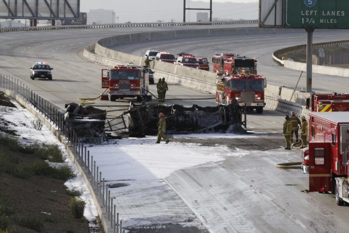Los Angeles County firefighters work to clean up the charred remains of an overturned tanker that ignited April 26 on the 710 Freeway.