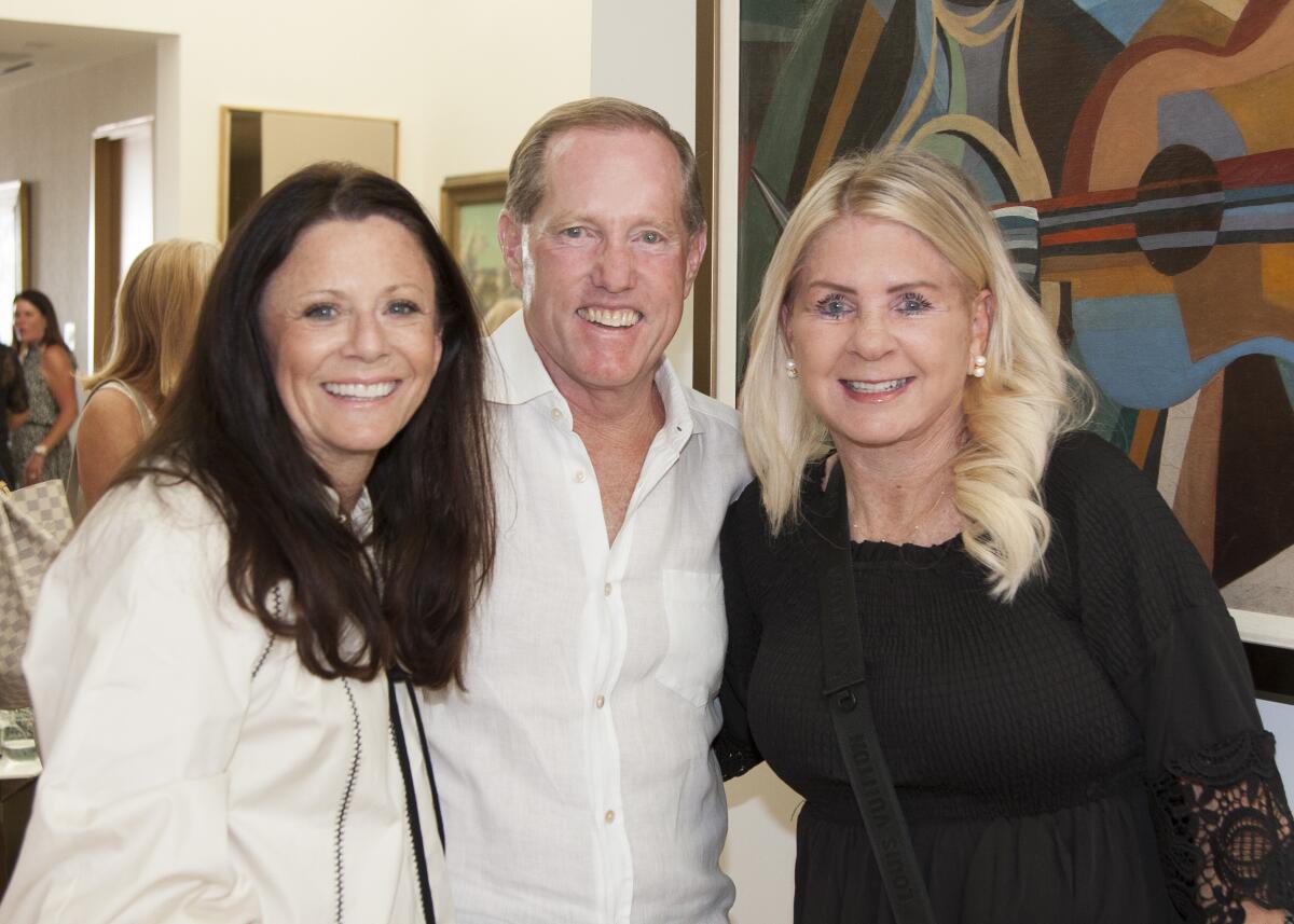 Joannie and Eric Davidson, co-chairs of the Roy Emerson Tennis Classic, smile with Chris Garber.