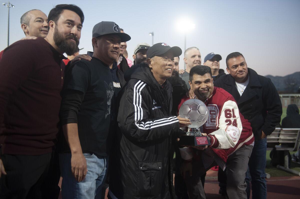 Former Burroughs High boys soccer coach Mike Kodama, center. poses for a photo with members of the 1994 team that went to finals during Thursday's tribute to his time with the team. (Photo by Miguel Vasconcellos)