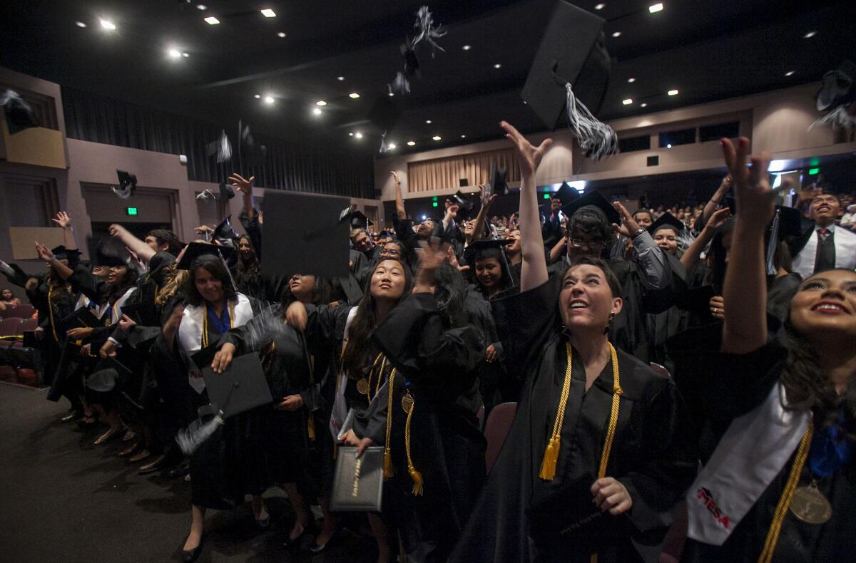 Graduates toss their caps during the Early College High School commencement ceremony on June 5, 2014.