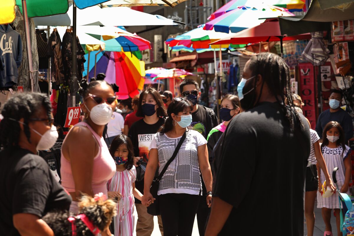 Shopper in masks walk down Santee Alley next to vendors' stalls