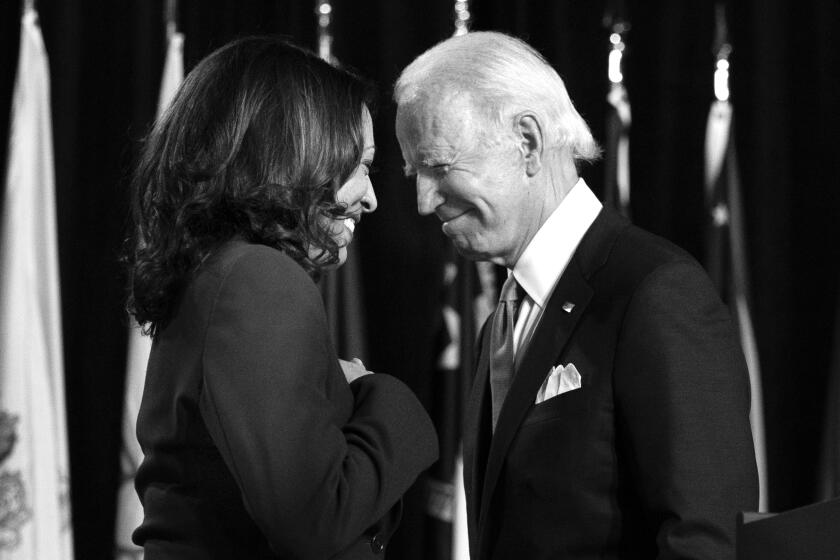 Democratic presidential candidate former Vice President Joe Biden and his running mate Sen. Kamala Harris, D-Calif., pass each other as Harris moves tot the podium. To speak during a campaign event at Alexis Dupont High School in Wilmington, Del., Wednesday, Aug. 12, 2020. (AP Photo/Carolyn Kaster)