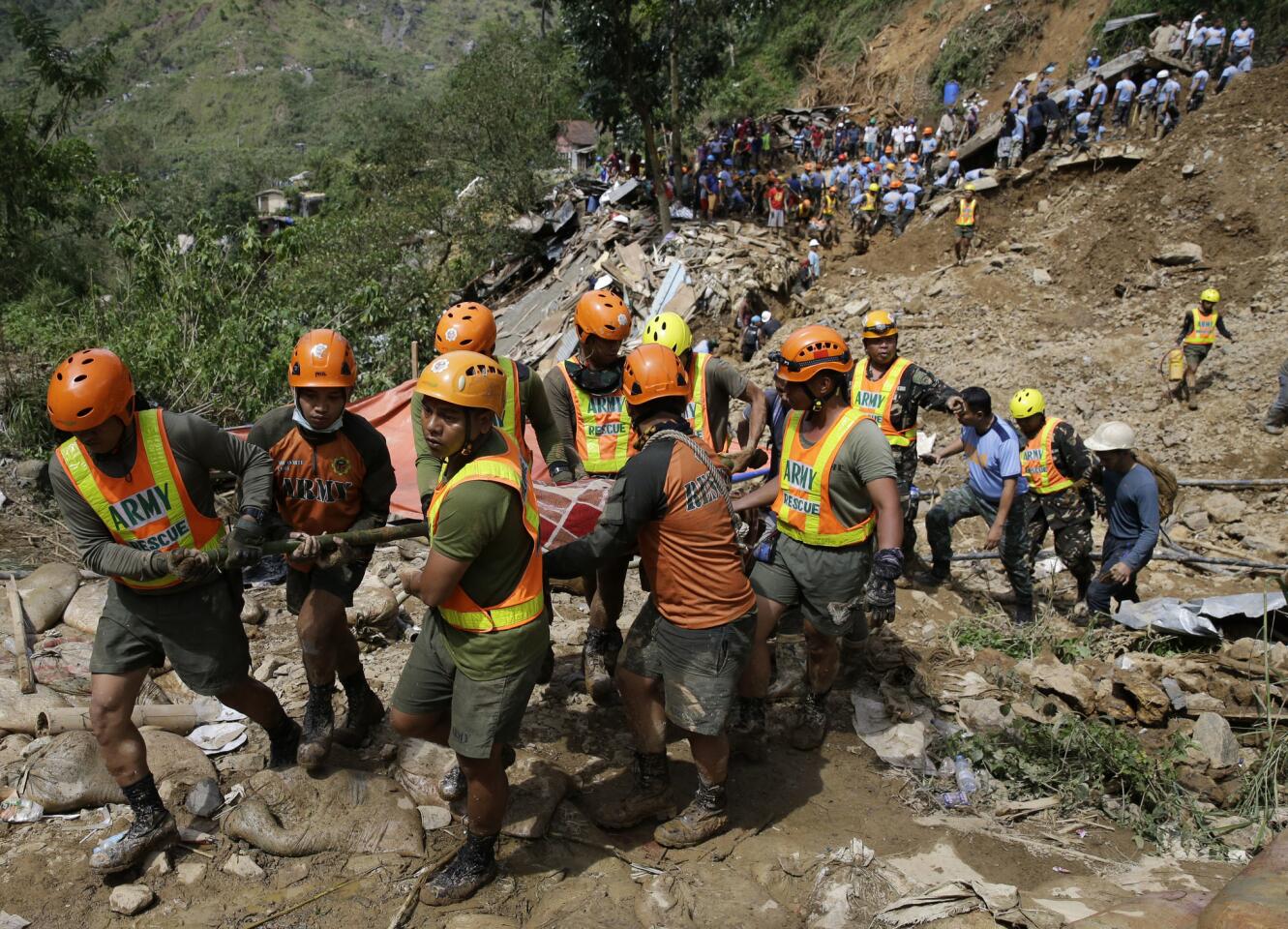 Rescuers carry a body recovered from a landslide caused by Typhoon Mangkhut in Itogon, Philippines.