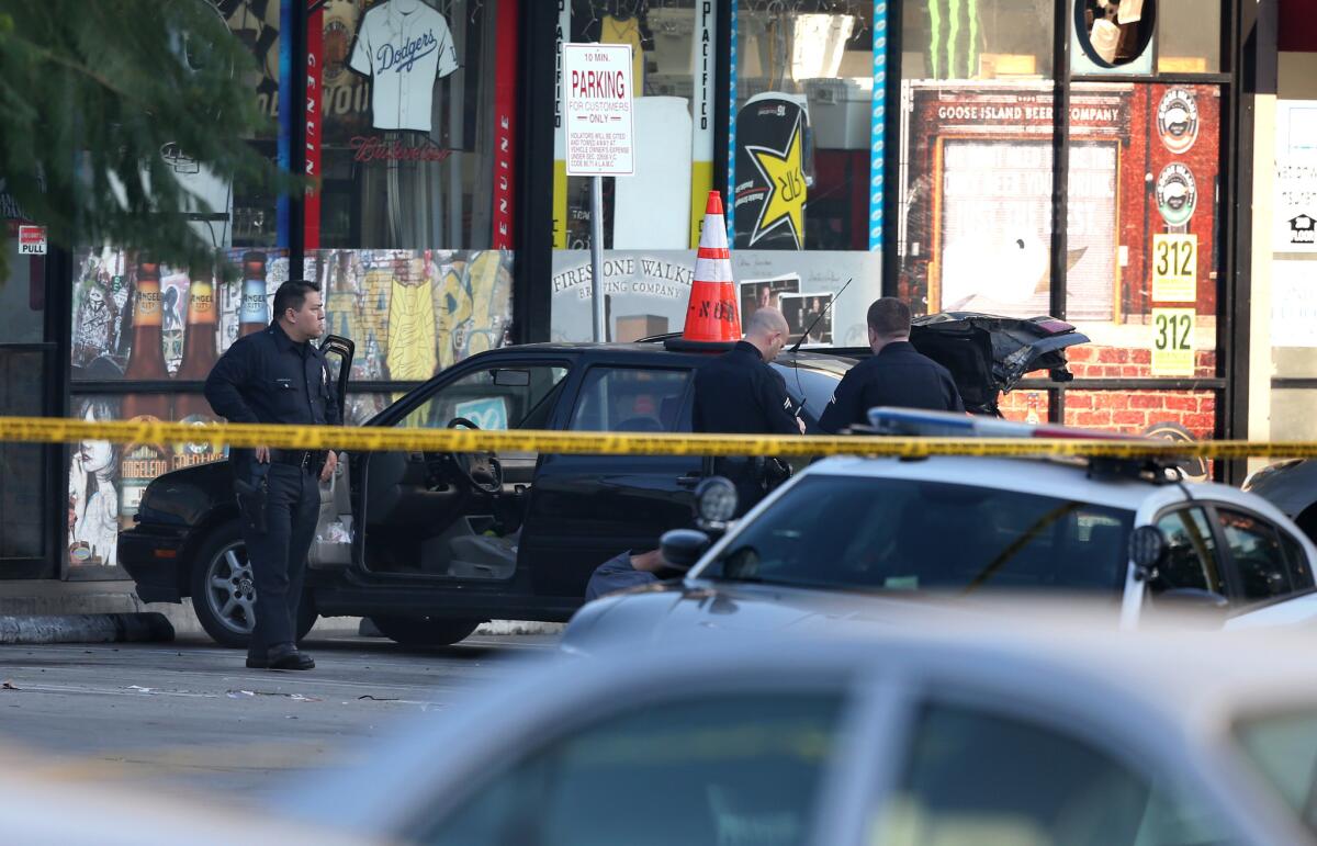 Los Angeles police inspect a car on Highland Avenue near the intersection of Hollywood Boulevard, over reports of explosives inside a car's trunk. No explosives were found, but police are canvassing the area out of caution.