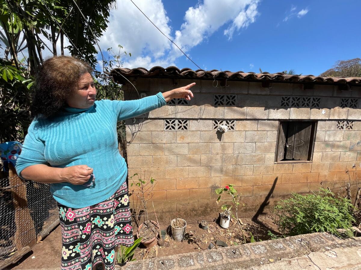 A woman points in her yard in Perquín, El Salvador