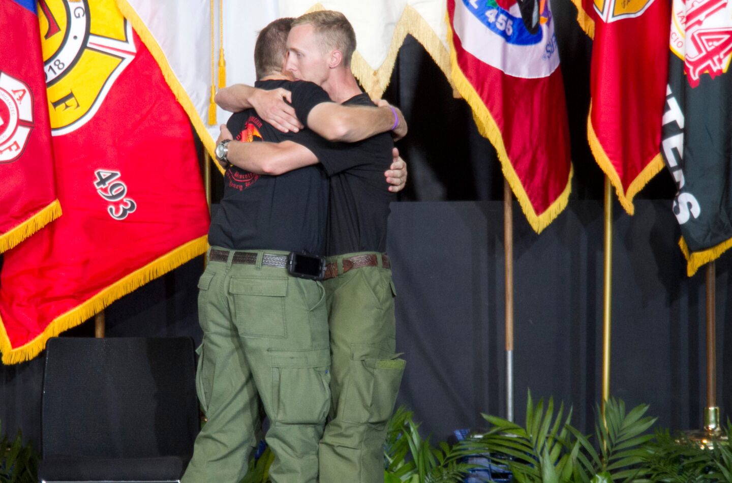 Brendan McDonough, right, the sole surviving member of the Granite Mountain Hotshots crew, hugs Darrell Willis, division chief of the Prescott Fire Department, during the memorial service.