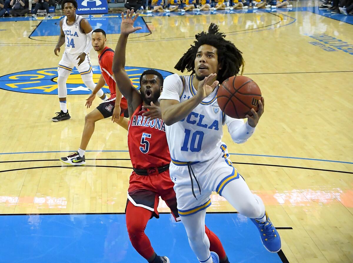 Arizona's Max Hazzard (5) guards UCLA's Tyger Campbell (10) as he drives to the basket in the first half at Pauley Pavilion on Feb. 29.