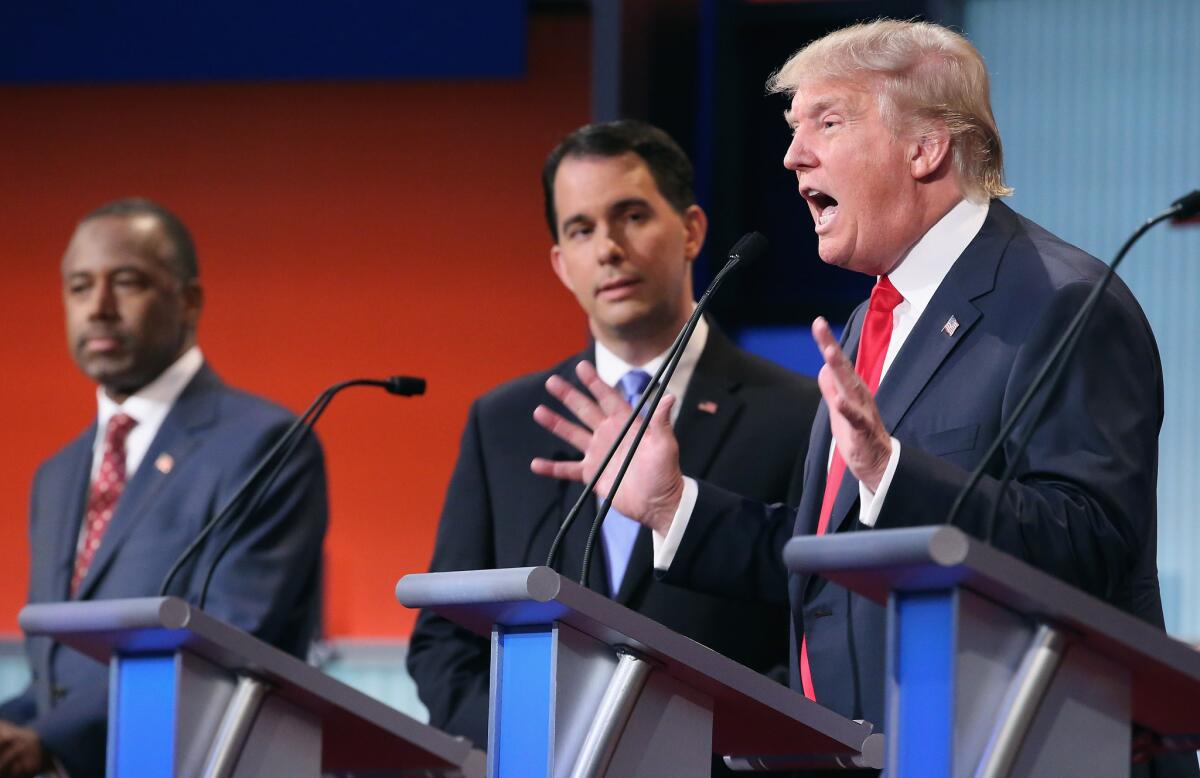 Ben Carson, left, Wisconsin Gov. Scott Walker and businessman Donald Trump participate in the Republican presidential debate on Aug. 6, which earned top ratings for Fox News.