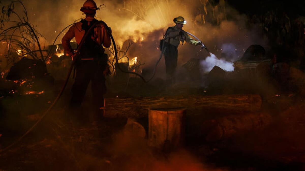 Fire crews hose down hot spots on North Rice Road in Ojai.