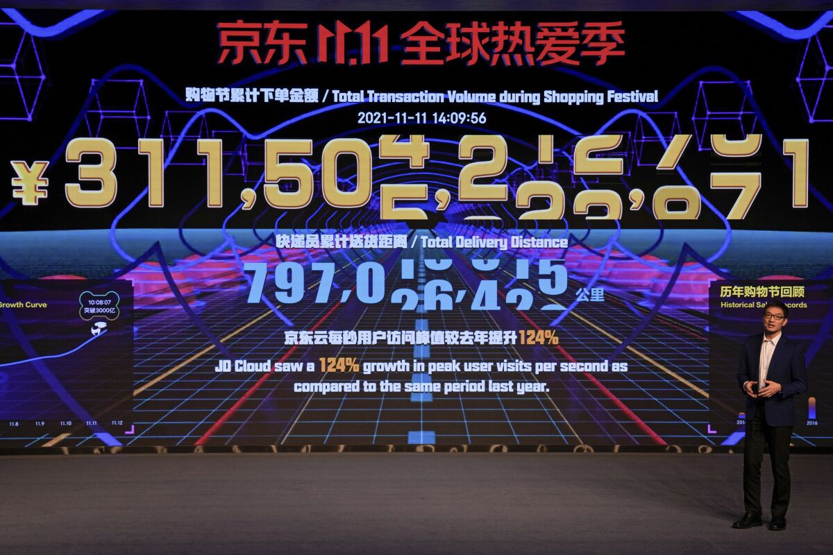 Liu Hui, Chief Data Officer of the JD Big Data Research Institute, speaks in front of a display showing live sales figures for China's biggest online shopping day, known as "Singles' Day" at the headquarters of online retailer JD.com in Beijing, Thursday, Nov. 11, 2021. China's biggest online shopping day, known as "Singles' Day" on Nov. 11, is taking on a muted tone this year as regulators crack down on the technology industry and President Xi Jinping pushes for "common prosperity." (AP Photo/Andy Wong)