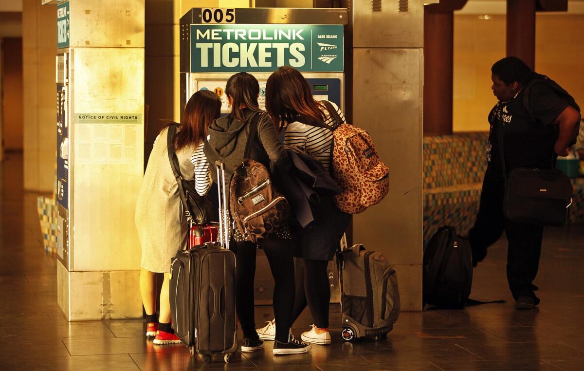 A group of Metrolink passengers crowd around a ticket vending machine at Patsaouras Transit Plaza in Union Station. According to rail officials, riders and complaints on social media, the devices have been breaking down with irritating frequency.