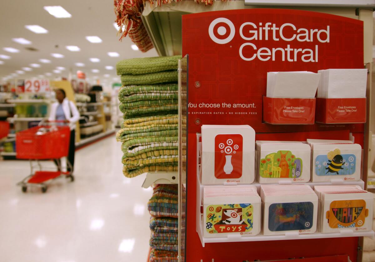 A lone shopper pushes a shopping cart past a display for gift cards at the Super Target in Glendale, Colo.