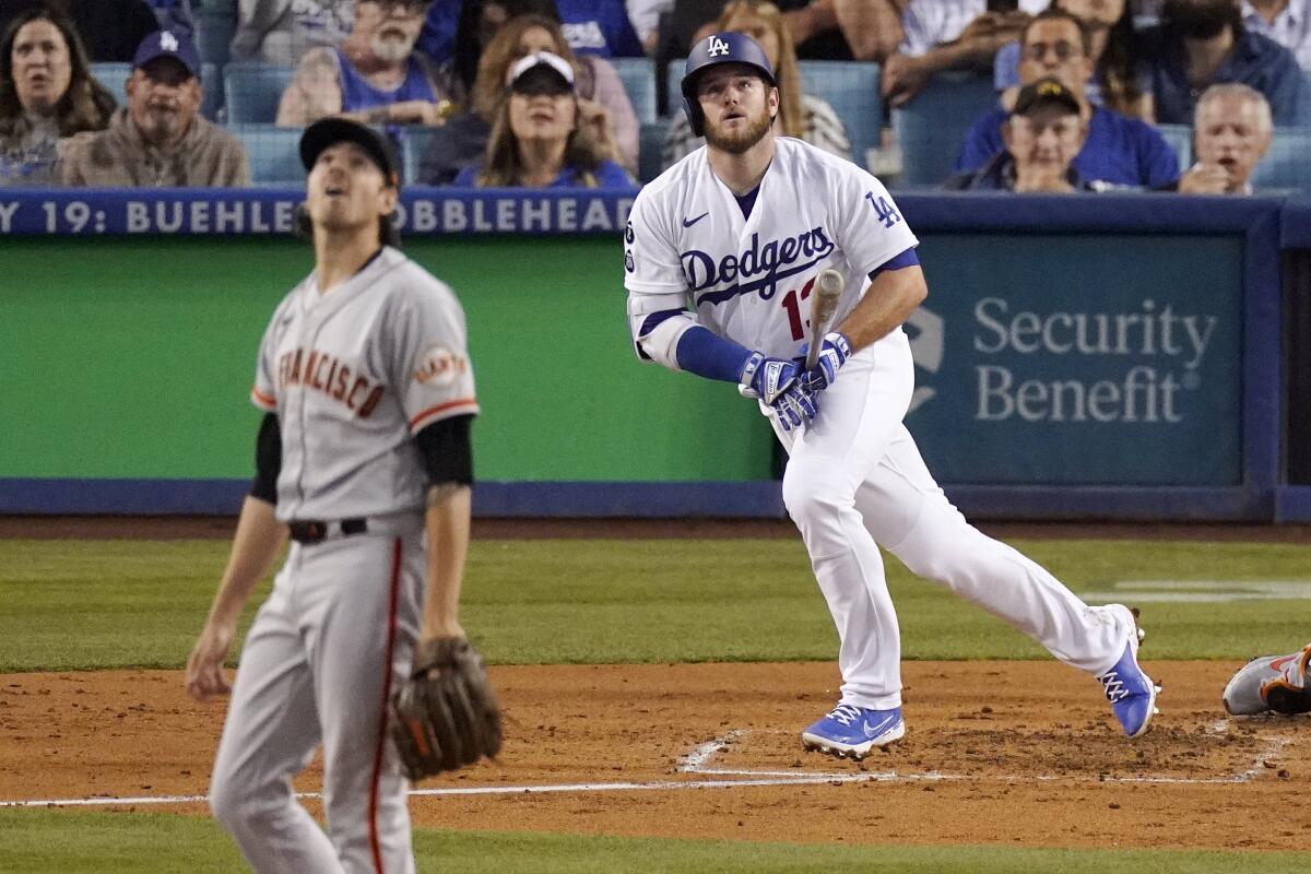 Max Muncy watches his solo home run against Kevin Gausman during the third inning. 