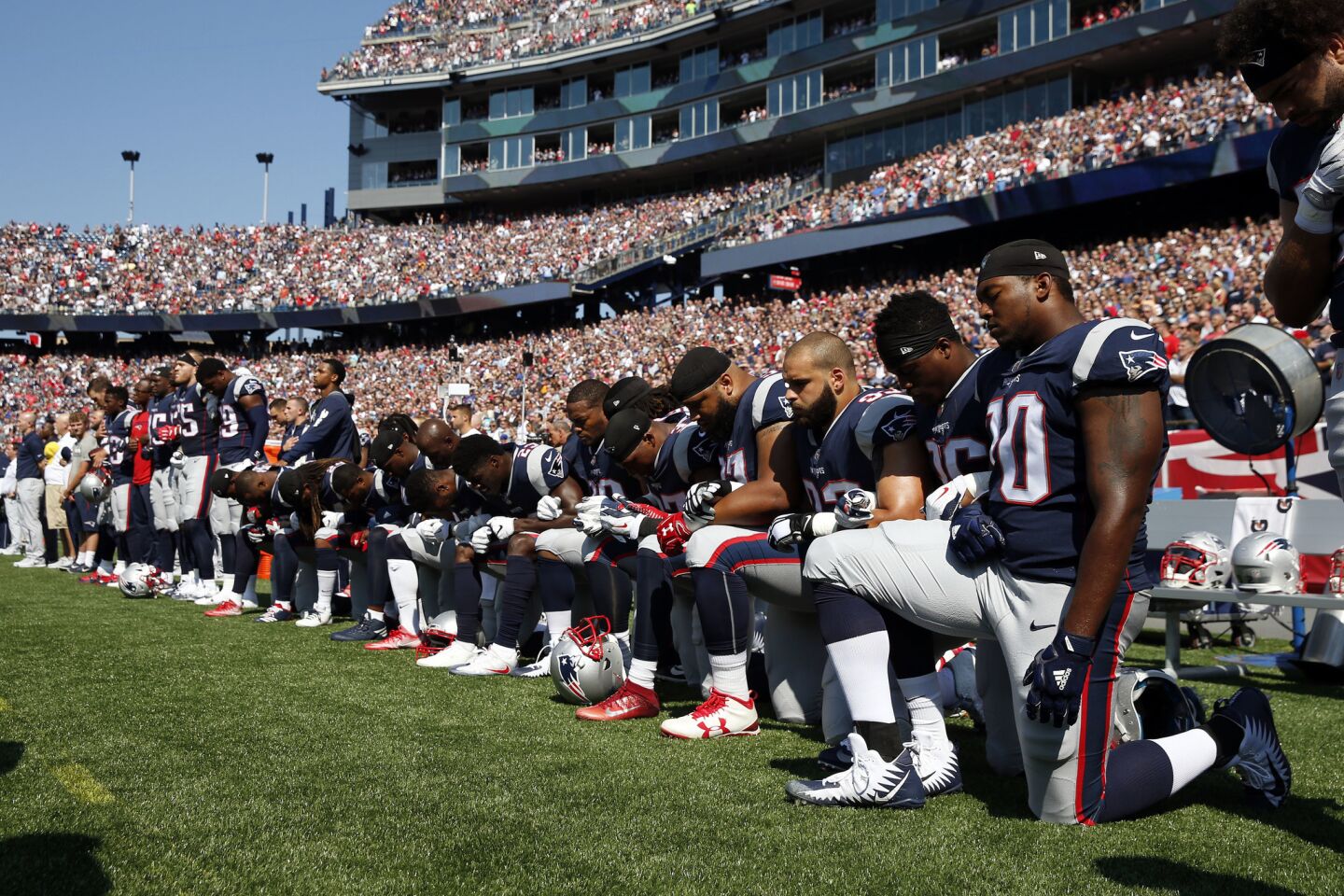 Several New England Patriots players kneel during the national anthem before a Sept. 24 game against