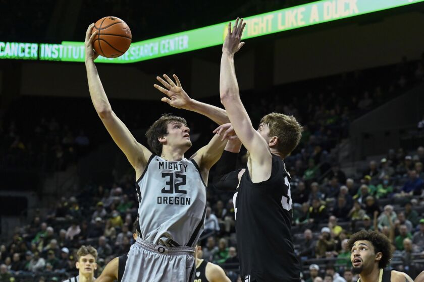 Oregon center Nate Bittle (32) shoots over Colorado center Lawson Lovering, center right, during the first half of an NCAA college basketball game Thursday, Jan. 26, 2023, in Eugene, Ore. (AP Photo/Andy Nelson)
