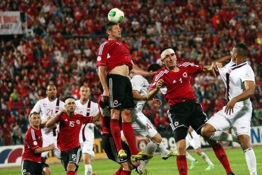 Edgar Cani of Albania heads the ball during a World Cup qualifying match against Norway.