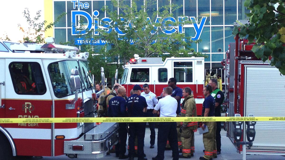Firefighters confer outside the Nevada Discovery Museum in Reno, where a science experiment went awry.