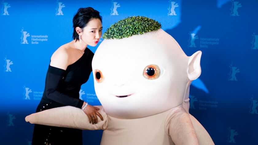 Actress Baihe Bai kisses a person dressed as the character Wuba from the film 'Monster Hunt 2' during a Feb. 18 photo-call at the International Film Festival Berlin.