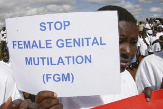 FILE - A Masai girl holds a protest sign during the anti-Female Genital Mutilation (FGM) run in Kilgoris, Kenya, on April 21, 2007. Lawmakers in the West African nation of Gambia on Monday July 15, 2024 rejected a bill that would have overturned a ban on female genital cutting. The attempt to become the first country in the world to reverse such a ban had been closely followed by activists abroad. (AP Photo/Sayyid Azim, File)