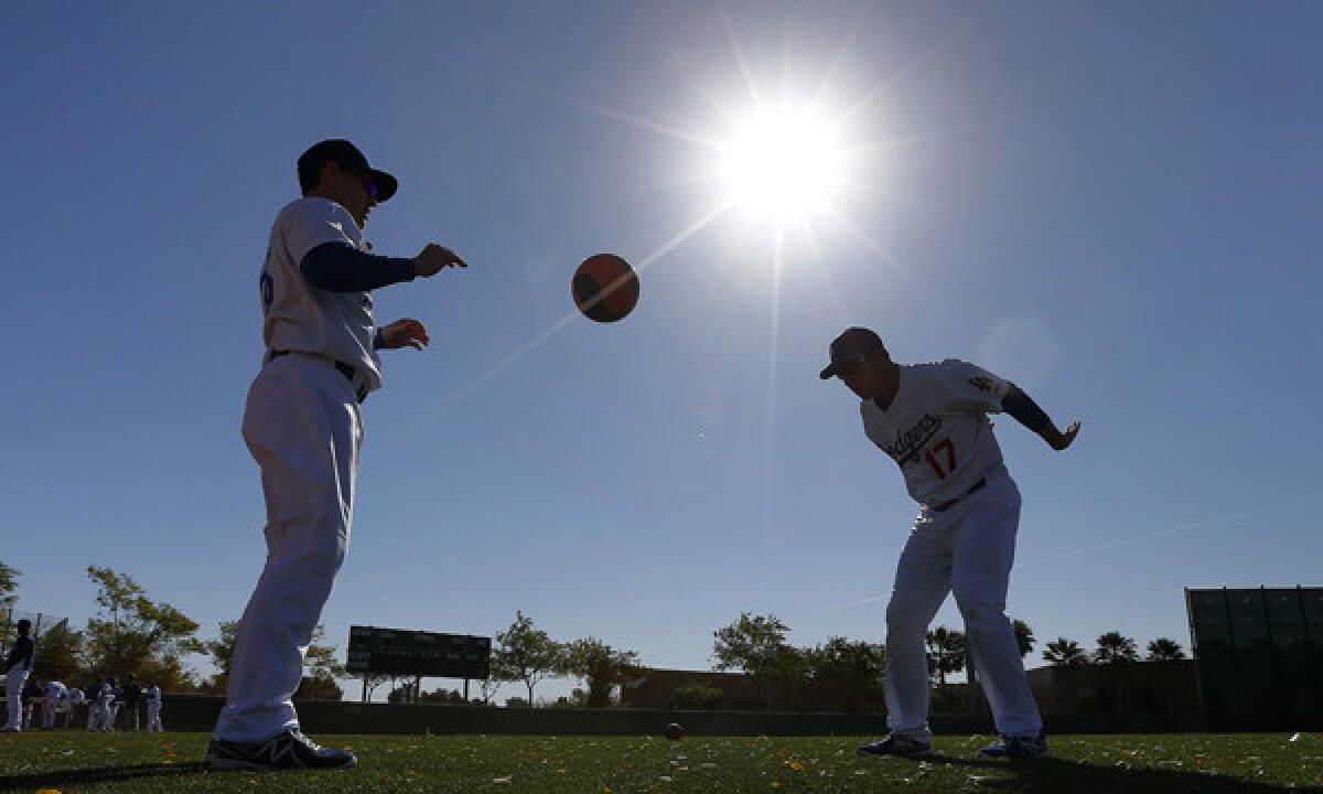 Brendan Harris, left, and A.J. Ellis work out with a heavy ball Thursday at Camelback Ranch in Glendale, Ariz.