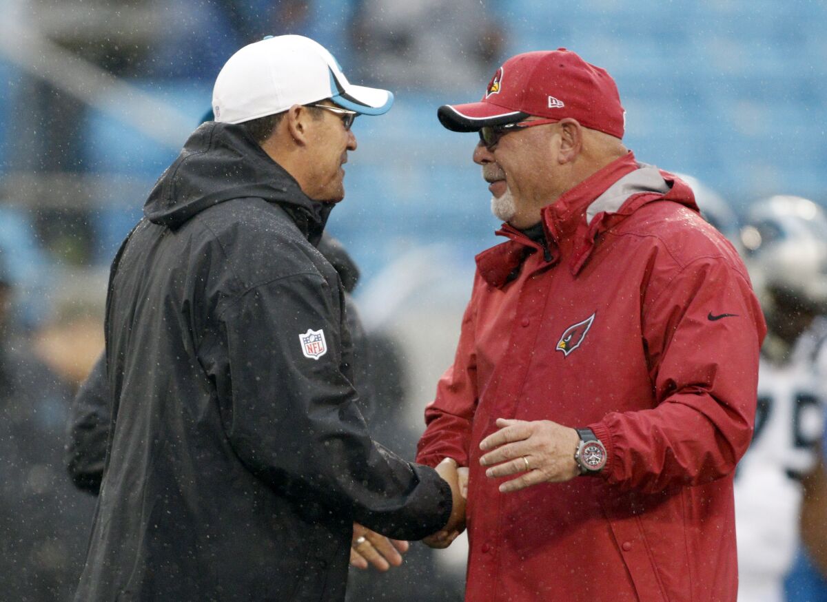 FILE - In this Jan., 3, 2015 file photo, Carolina Panthers coach Ron Rivera, left, greets Arizona Cardinals coach Bruce Arians before an NFL wild-card playoff football game in Charlotte, N.C. Rivera is now the coach of the Washington Football Team, and Arians is the coach of the Tampa Bay Buccaneers. Those two teams meet in the wild-card round this weekend; Washington was 7-9 in the regular season. (AP Photo/Bob Leverone, File)