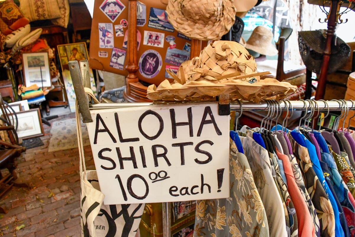 A clothing rack with a sign that reads "aloha shirts 10.00 each!"
