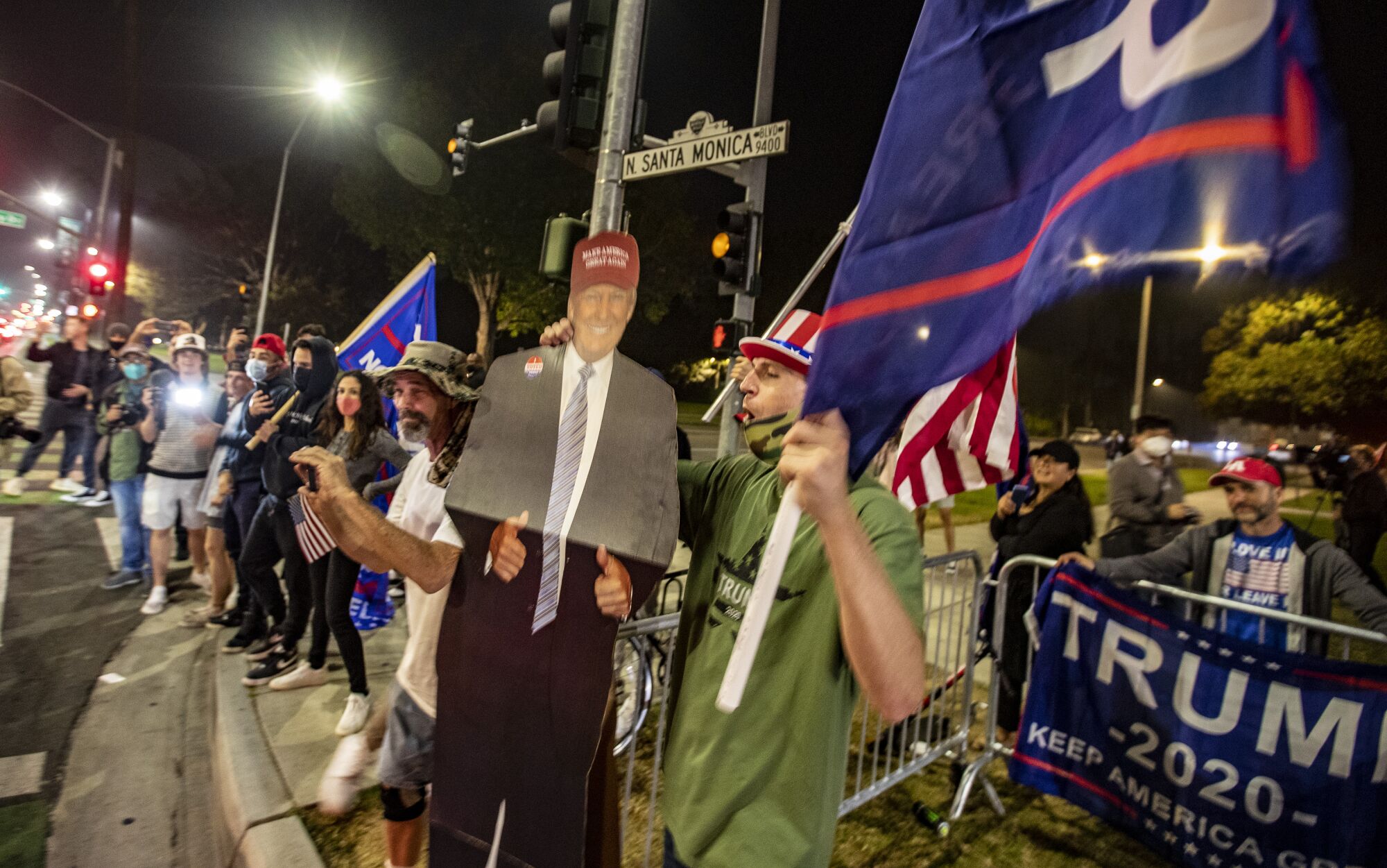 Trump supporters wave flags and cheer at Beverly Gardens Park on Tuesday night.