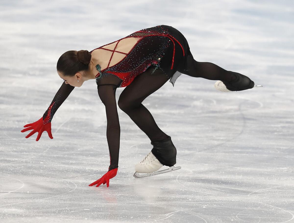 Skater Kamila Valieva reaches with her arms as she stumbles. 