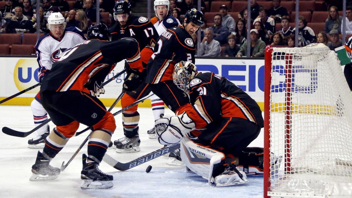 Ducks goalie Frederik Andersen tries to smother the puck in the crease in the first period of Friday night's game against the Columbus Blue Jackets.
