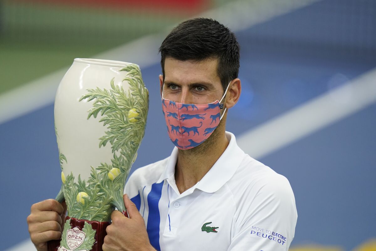 Novak Djokovic holds the championship trophy after winning the Western & Southern Open in New York.