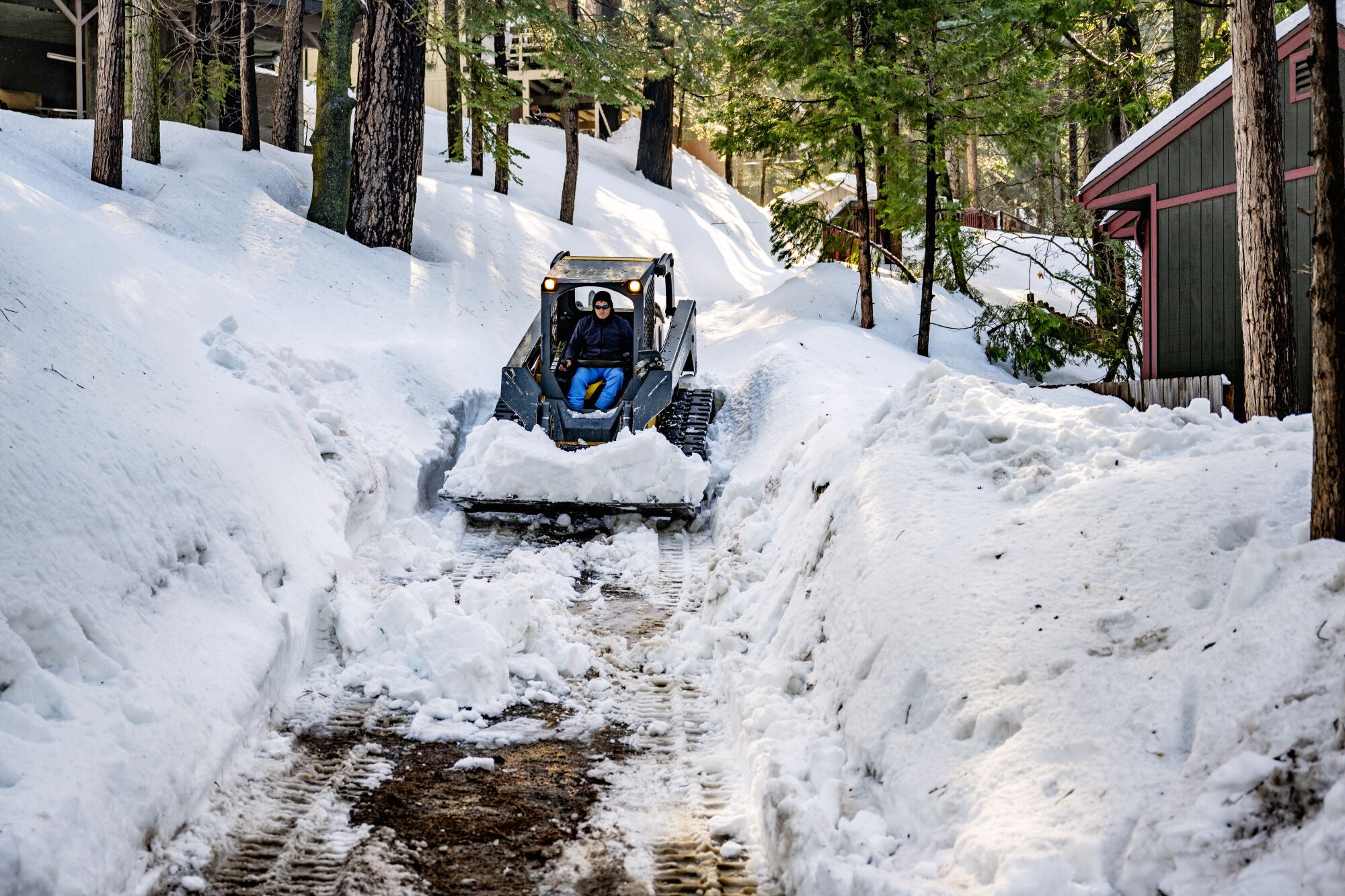A volunteer drives an all-terrain vehicle through a snow-filled driveway