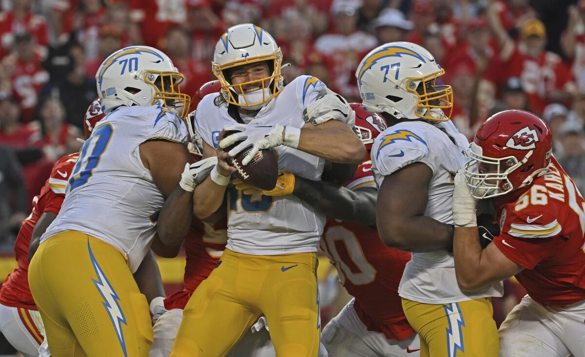 Chargers quarterback Justin Herbert (10) gets sacked by Kansas City Chiefs defensive end Charles Omenihu (90).