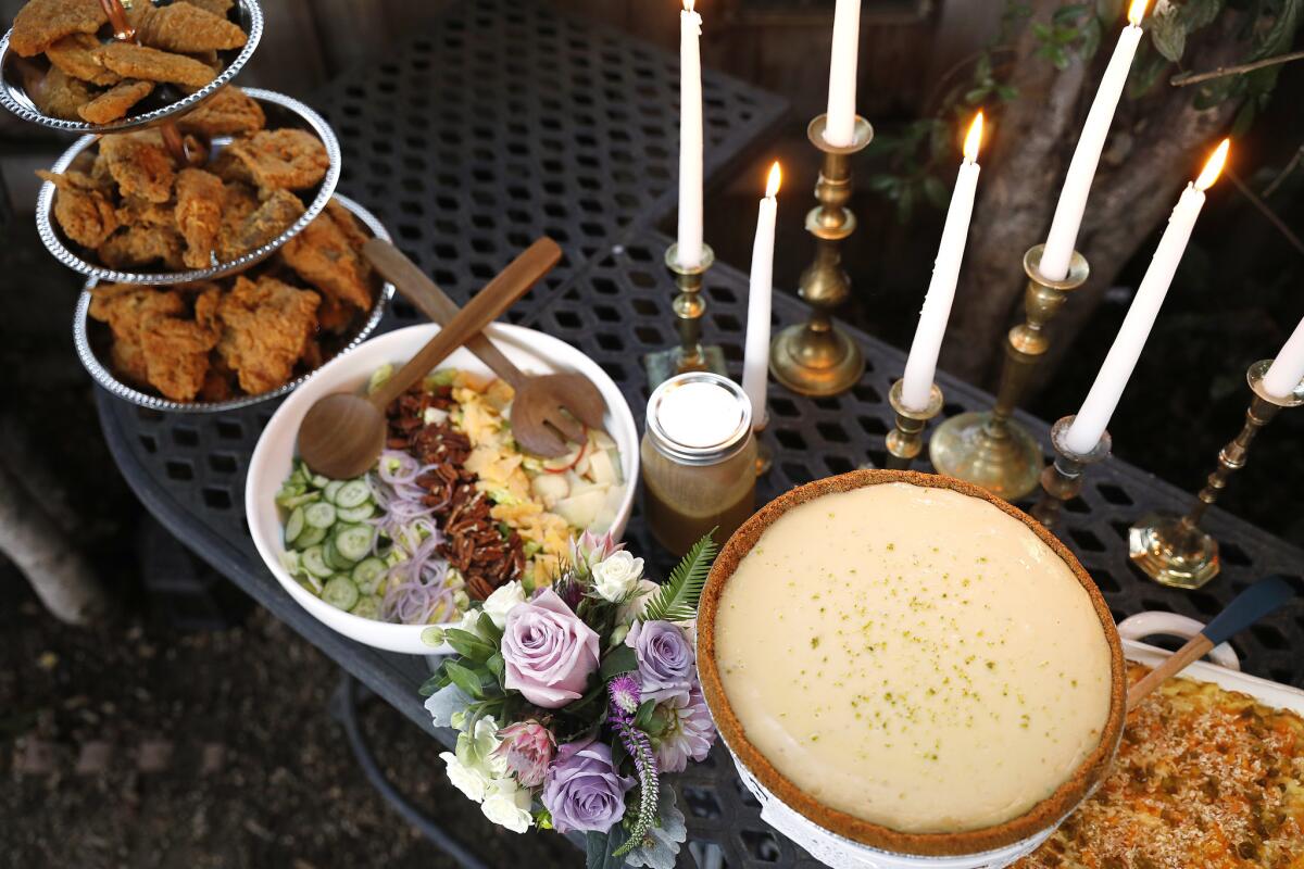 Fried chicken, shaved apple salad with onion, toasted pecans and aged gouda cheese, The key lime pie from Winston's Pies, and mac and cheese, from left, are served at a fried chicken party in Los Angeles.