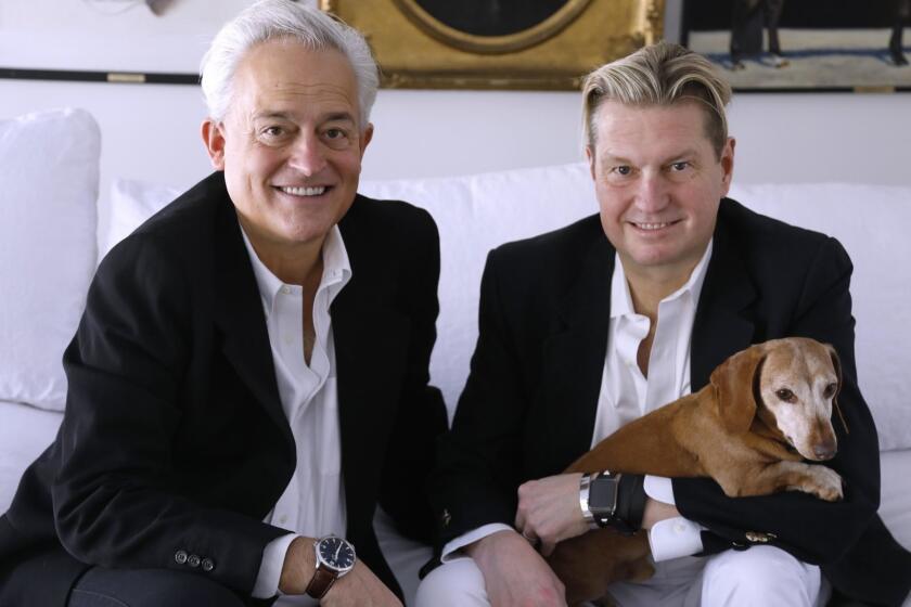BEVERLY HILLS, CA - JANUARY 4, 2019 - - Fashion designers Mark Badgley, left, and James Mischka, holding Rommel, at their home in Beverly Hills on January 4, 2019. Badgley and Mischka are the founders of 30-year old New York-based couture brand Badgley Mischka. They have recently bought this home in Beverly Hills, opened a new flagship store on Sunset Boulevard and expanded into various other categories, including men?s, home and fragrance. (Genaro Molina/Los Angeles Times)