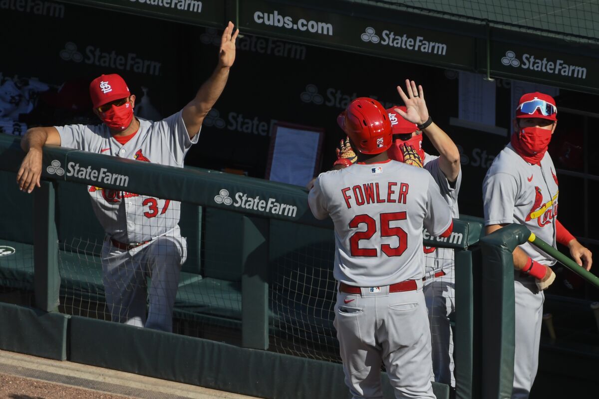 St. Louis Cardinals' Dexter Fowler (25) celebrates in the dugout after his home run in the third inning of Game 1 of a baseball doubleheader against the Chicago Cubs, Monday, Aug. 17, 2020, in Chicago. (AP Photo/Matt Marton)
