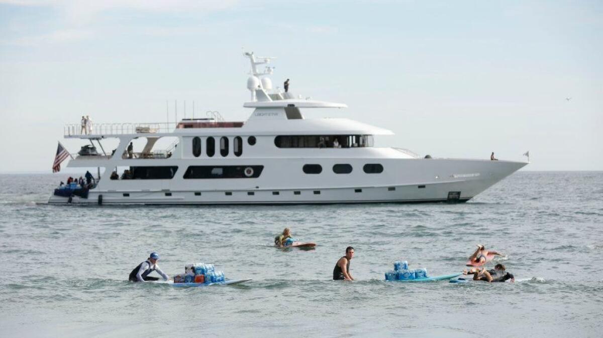 Residents and volunteers bring in supplies for those in Malibu off of a billionaire's yacht.