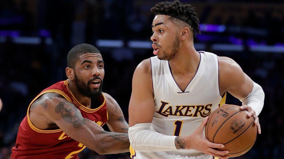 Lakers' D'Angelo Russell, right, is pressured by Cleveland Cavaliers' Kyrie Irving during the first half Sunday.