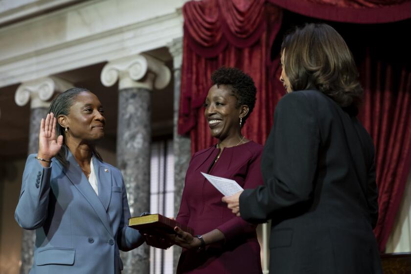 Vice President Kamala Harris, right, swears in Laphonza Butler, D-Calif., left, to the Senate to succeed the late Sen. Dianne Feinstein during a re-enactment of the swearing-in ceremony on Tuesday, Oct. 3, 2023, on Capitol Hill in Washington. Butler's wife, Neneki Lee, center, holds the Bible. (AP Photo/Stephanie Scarbrough)