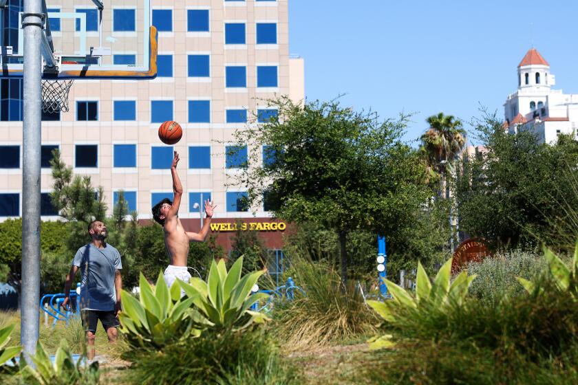 LONG BEACH-CA-JULY 3, 2024: Two men play a game of basketball at Lincoln Park in Long Beach on July 3, 2024. (Christina House / Los Angeles Times)