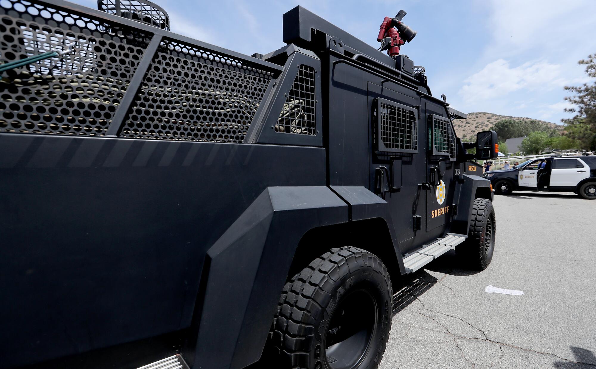 A black vehicle with window grates resembles a pickup truck with an elongated bed.